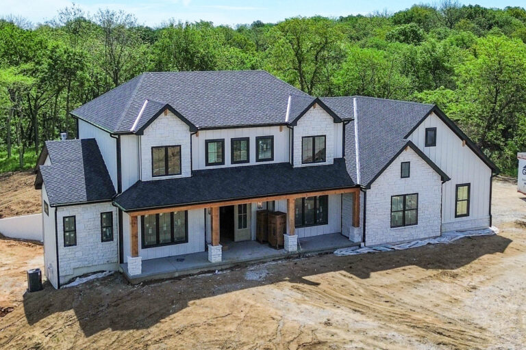 Front view of a white modern farmhouse with new 5-inch black gutters in Smithville, MO.