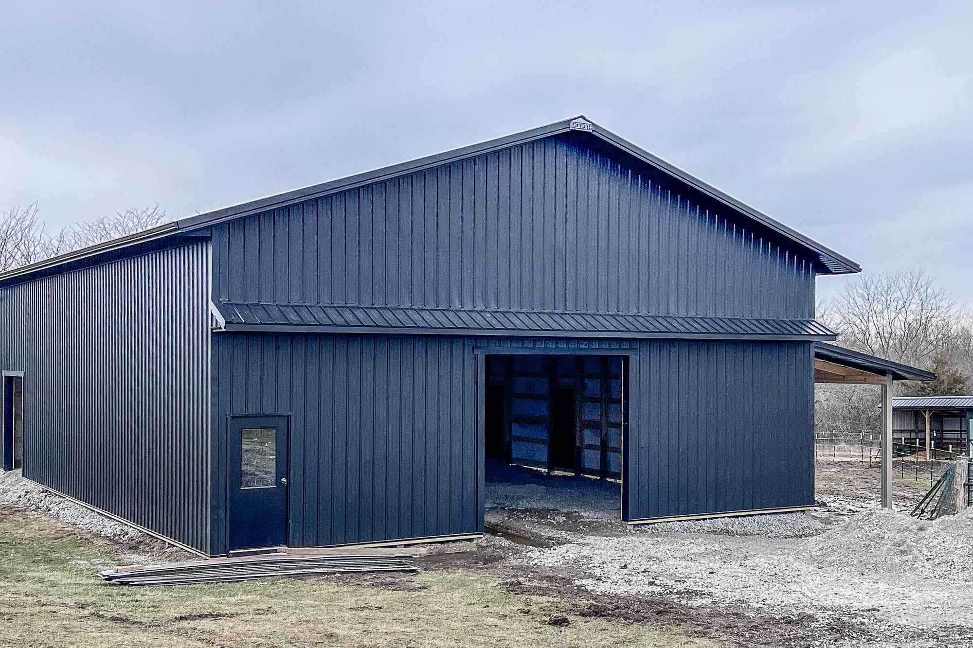 Side view of a large metal building with black seamless gutters in Cameron, MO.