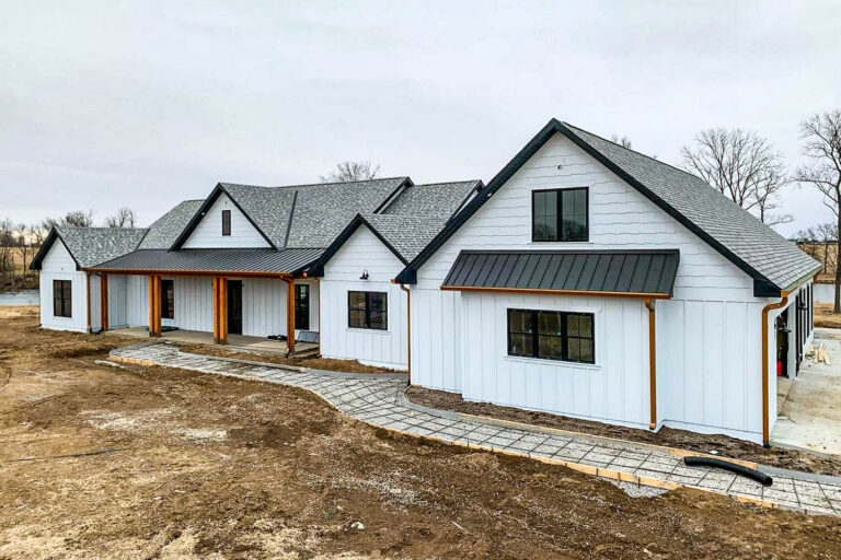 White farmhouse-style building with 6-inch copper gutters installed by Gutter Tech in Carrollton, Missouri.