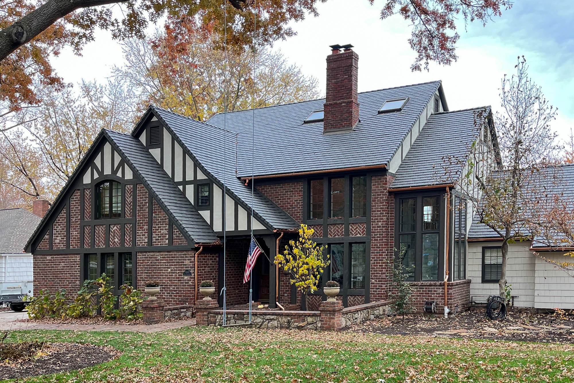 Full view of Tudor-style home with copper gutters installed along multiple roof elevations on a house in Leawood KS