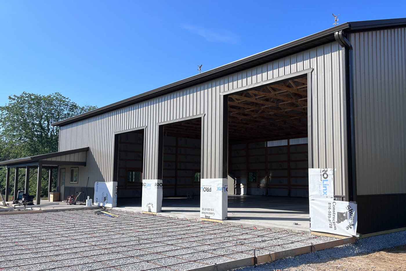Metal building in Kearney, Missouri with new 6-inch black seamless gutters and downspouts installed by Gutter Tech.