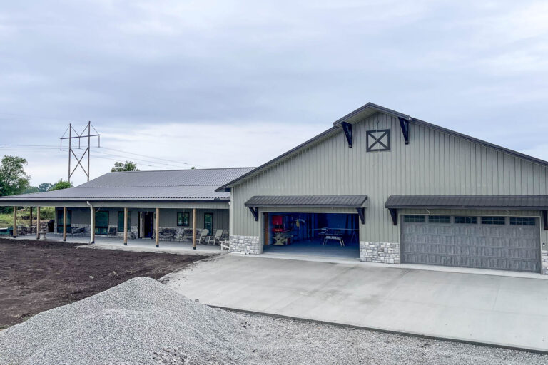 Large metal-roof building with new 6-inch black gutters and downspouts installed by Gutter Tech in Berlin, Kansas.
