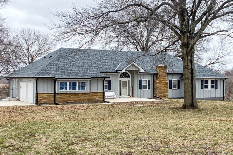 Front view of a residential home in Buckner, Missouri with new 6-inch black gutters and Extreme Guard protection